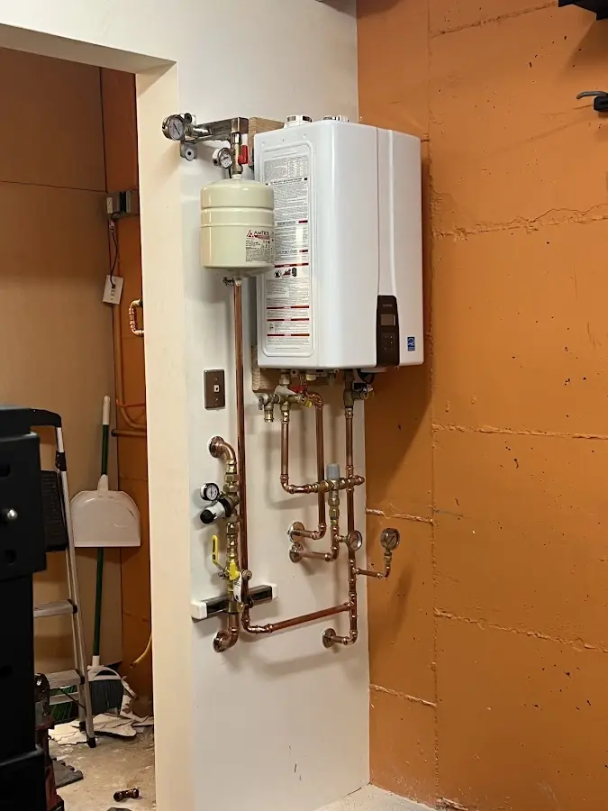 Plumbing technician inspecting water heater connections in Gloucester City